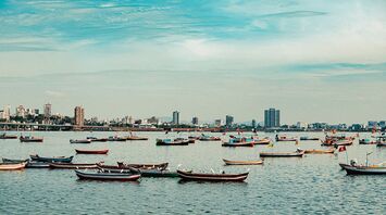 Boats in Mumbai with city skyline in the background