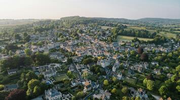 Aerial view of a charming village in the South Cotswolds, featuring historic buildings and lush greenery