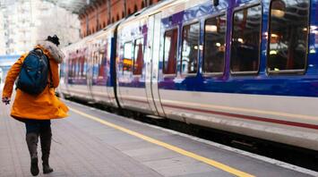 A passenger running to catch a train at a London railway station
