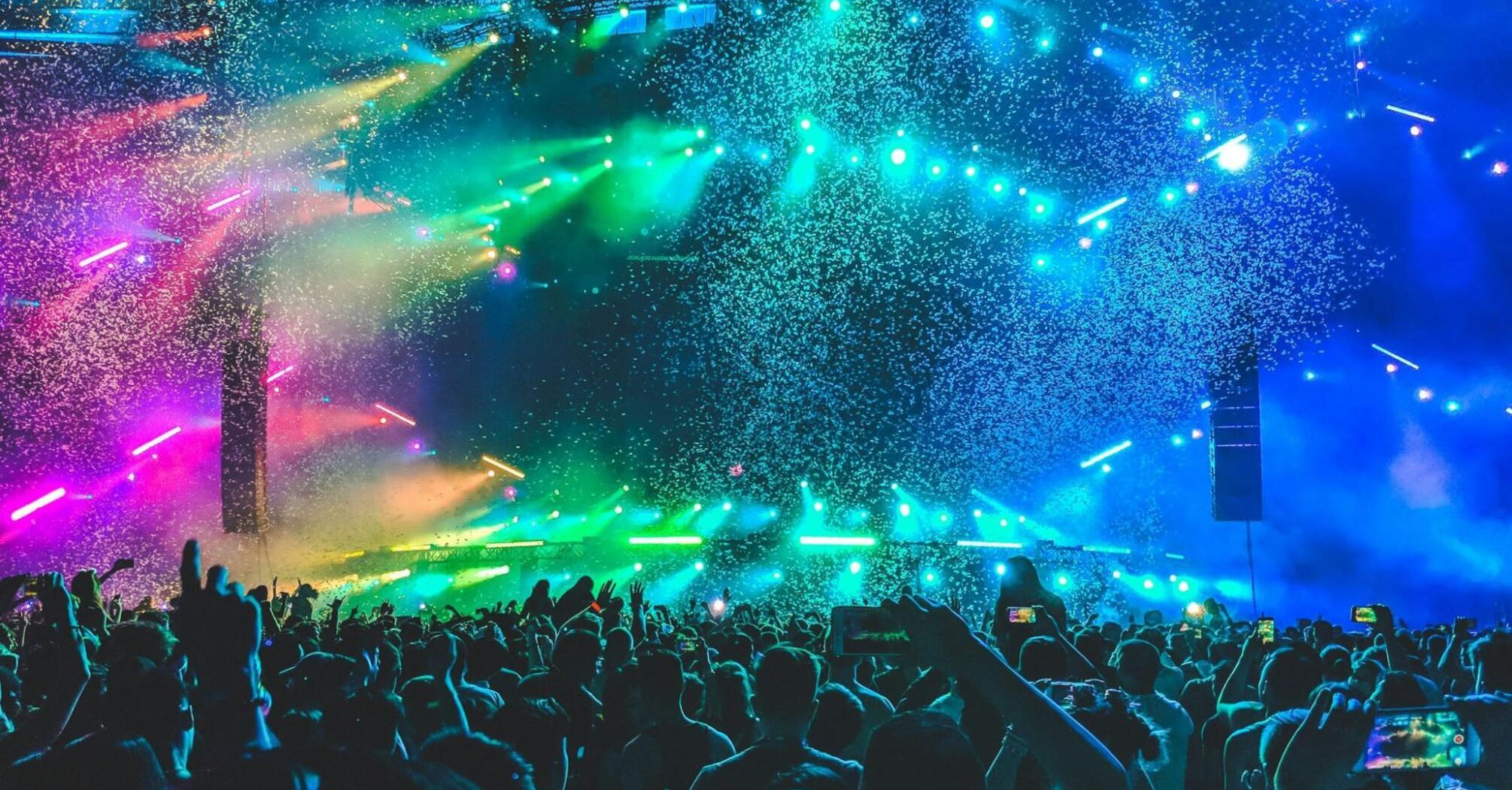 Crowd enjoying a colorful light show at a music festival