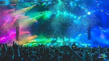 Crowd enjoying a colorful light show at a music festival