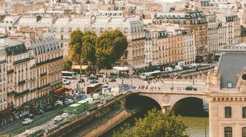 A scenic view of Paris with the Eiffel Tower in the background and the Seine River in the foreground