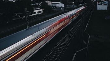 A train passing through a station at dusk