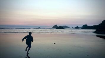 A kid running to the Ocean