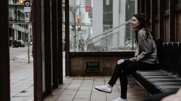 People waiting at a covered bus stop in an urban area