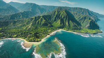Aerial view of lush mountains and coastline in Hawai‘i