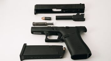 Disassembled handgun with bullets and magazine