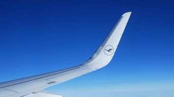 Lufthansa airplane wing against a clear blue sky