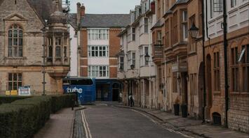 A quiet street with a blue bus in the background