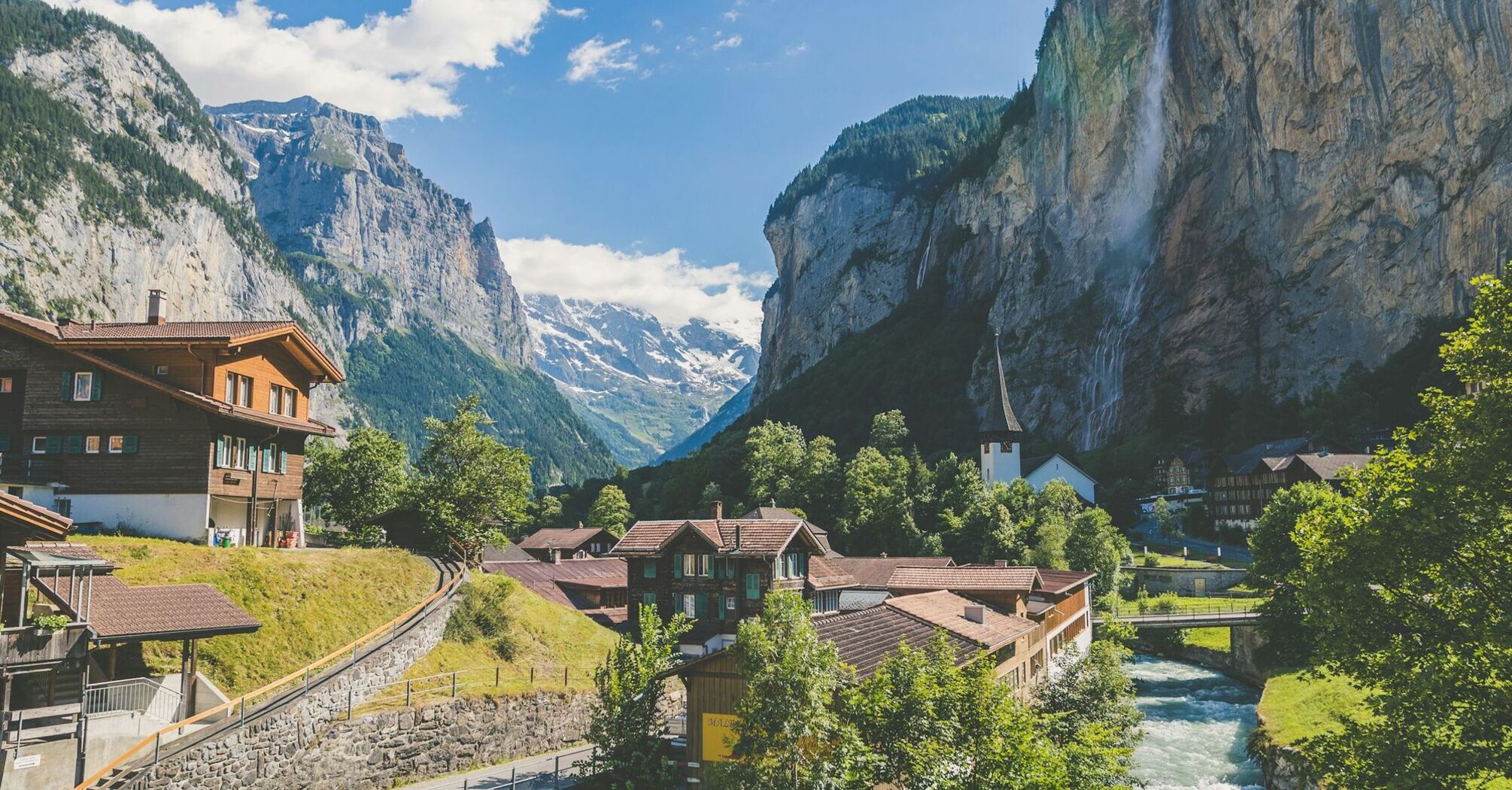 Scenic view of a Swiss village in the Alps with a waterfall and mountains in the background