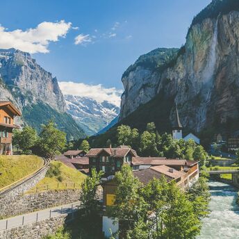 Scenic view of a Swiss village in the Alps with a waterfall and mountains in the background