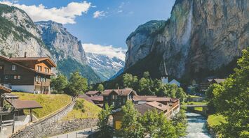 Scenic view of a Swiss village in the Alps with a waterfall and mountains in the background