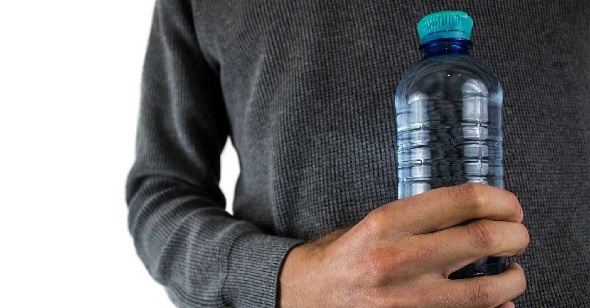 Person holding a plastic water bottle