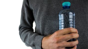 Person holding a plastic water bottle