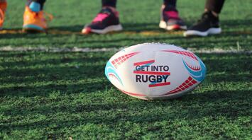 Rugby ball on a field with players in the background