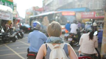 Traveler in a busy urban street with motorbikes