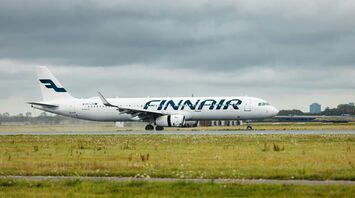 Finnair airplane landing and taxiing on a rainy day