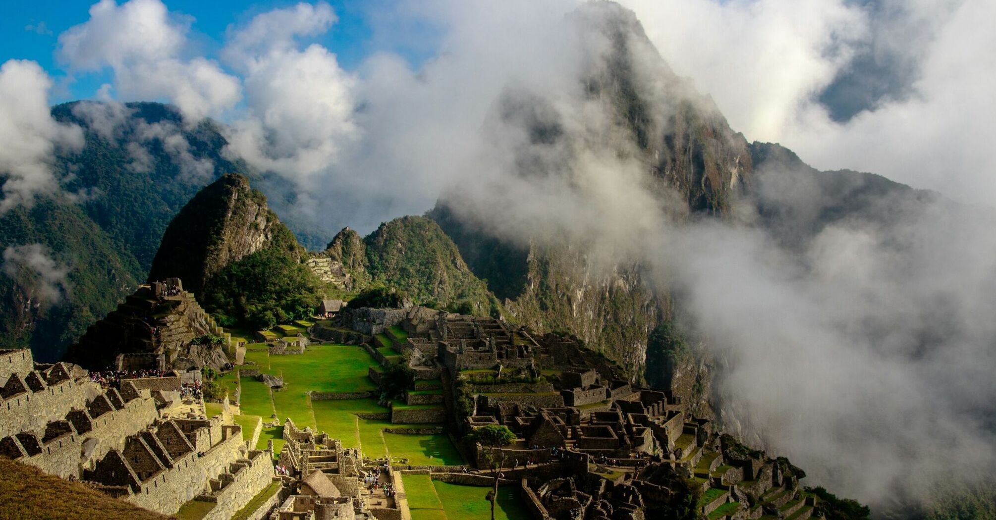 Aerial view of Machu Picchu with surrounding mountains and clouds