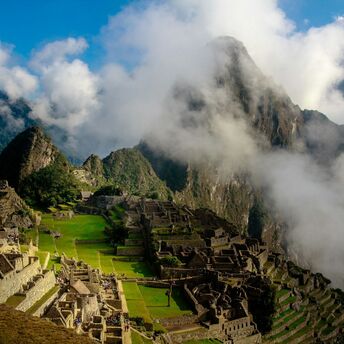 Aerial view of Machu Picchu with surrounding mountains and clouds