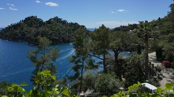 Scenic view of a bay and green hills under a blue sky, Italy