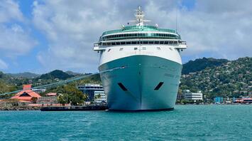 Large cruise ship moored at the port, city in the background