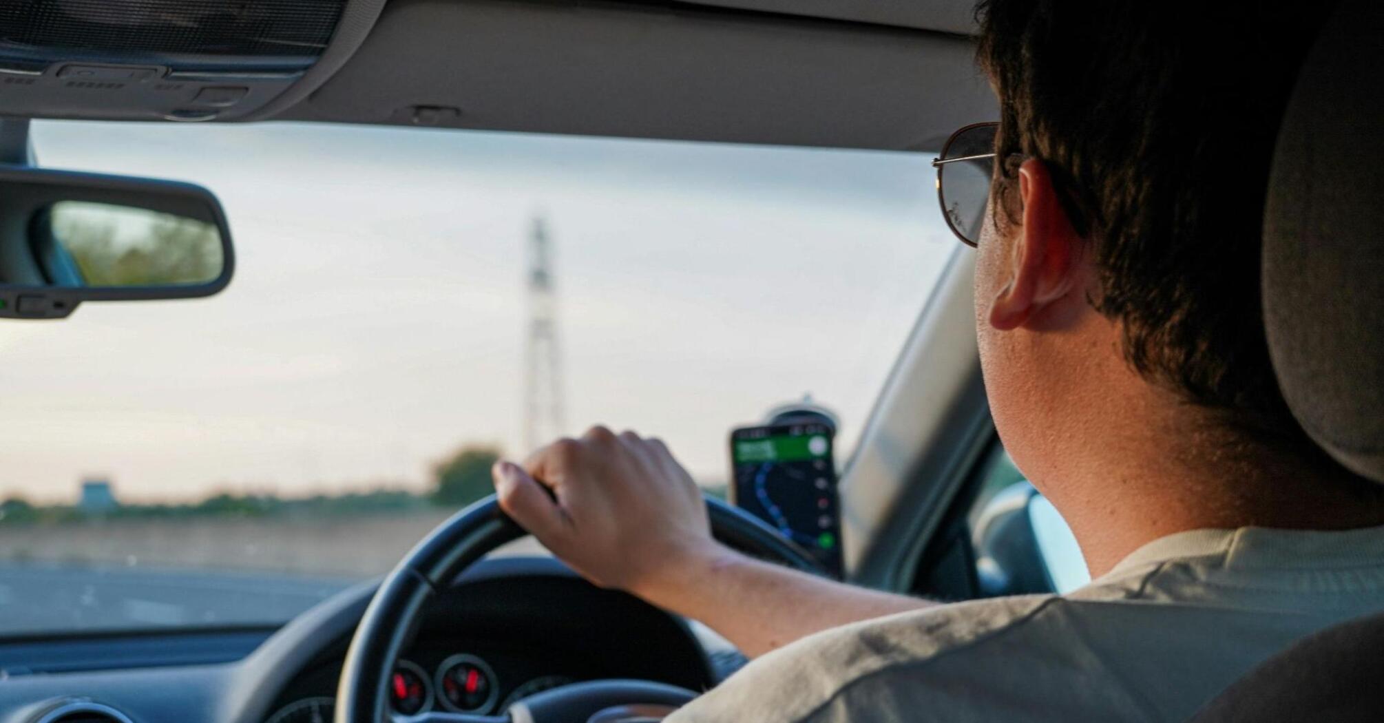 A driver in sunglasses drives a car with a navigator