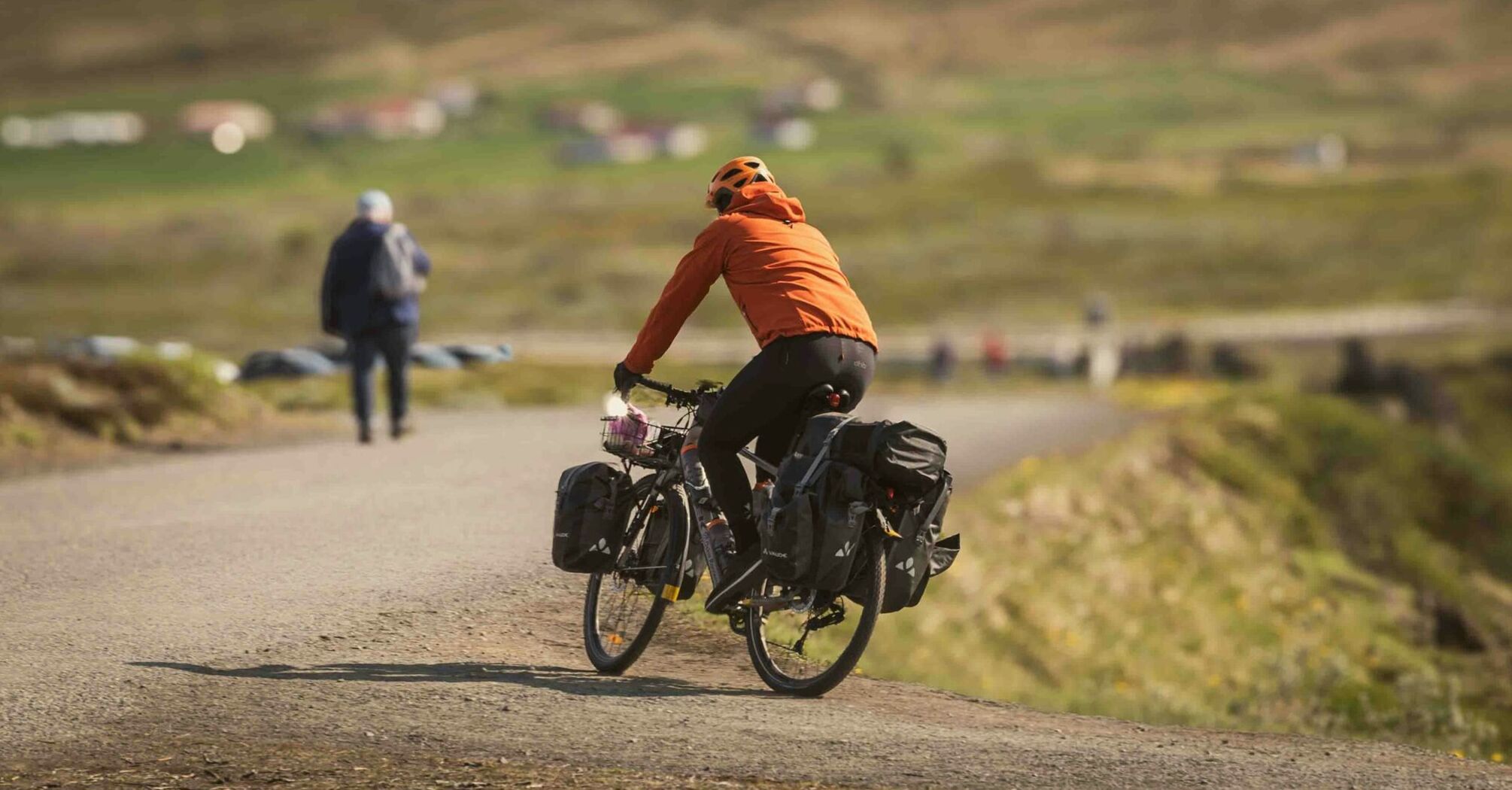 Person cycling on a rural path with scenic background