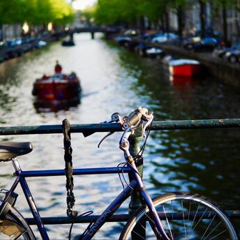 Bicycle on a bridge, canal and boat in the background