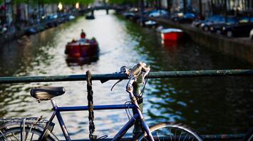 Bicycle on a bridge, canal and boat in the background