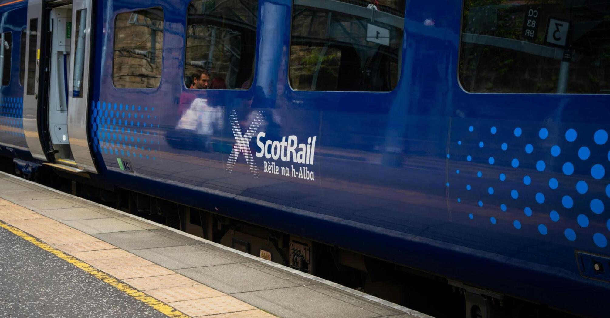 Blue ScotRail train on station platform with open door