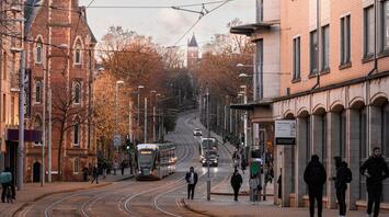 Tram and people on the street near the university building