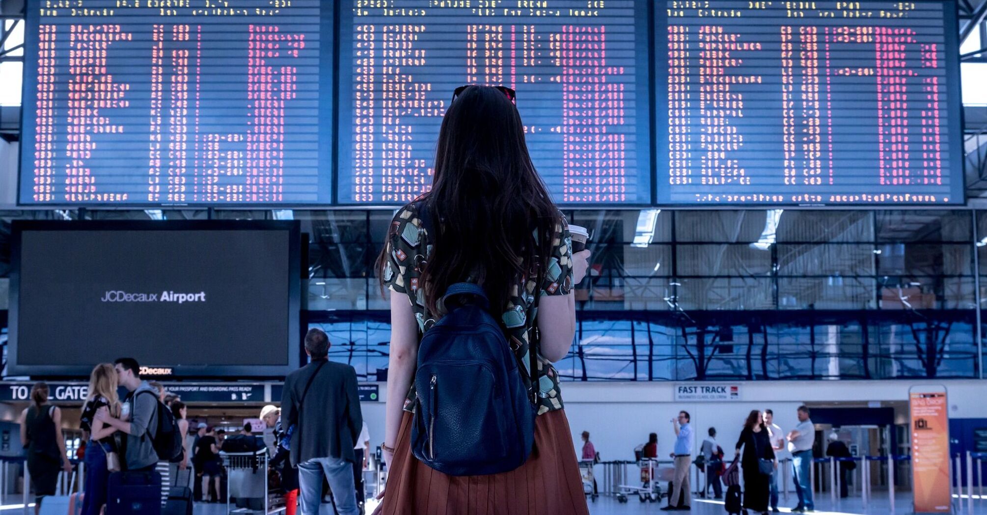 Traveler looking at flight information board in airport