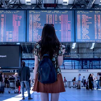 Traveler looking at flight information board in airport