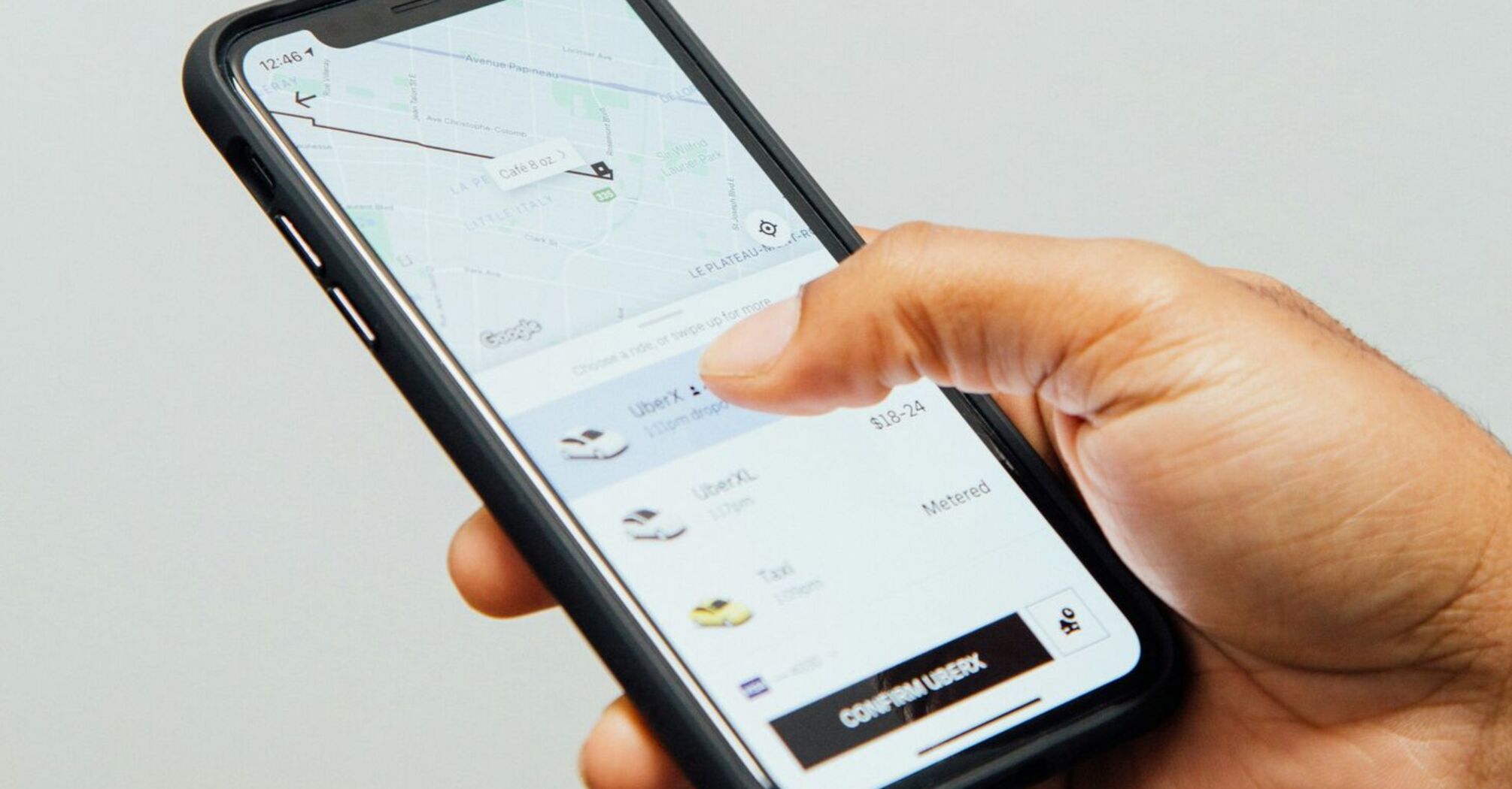 Hand holding smartphone with Uber app open
