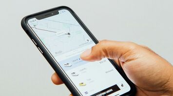 Hand holding smartphone with Uber app open