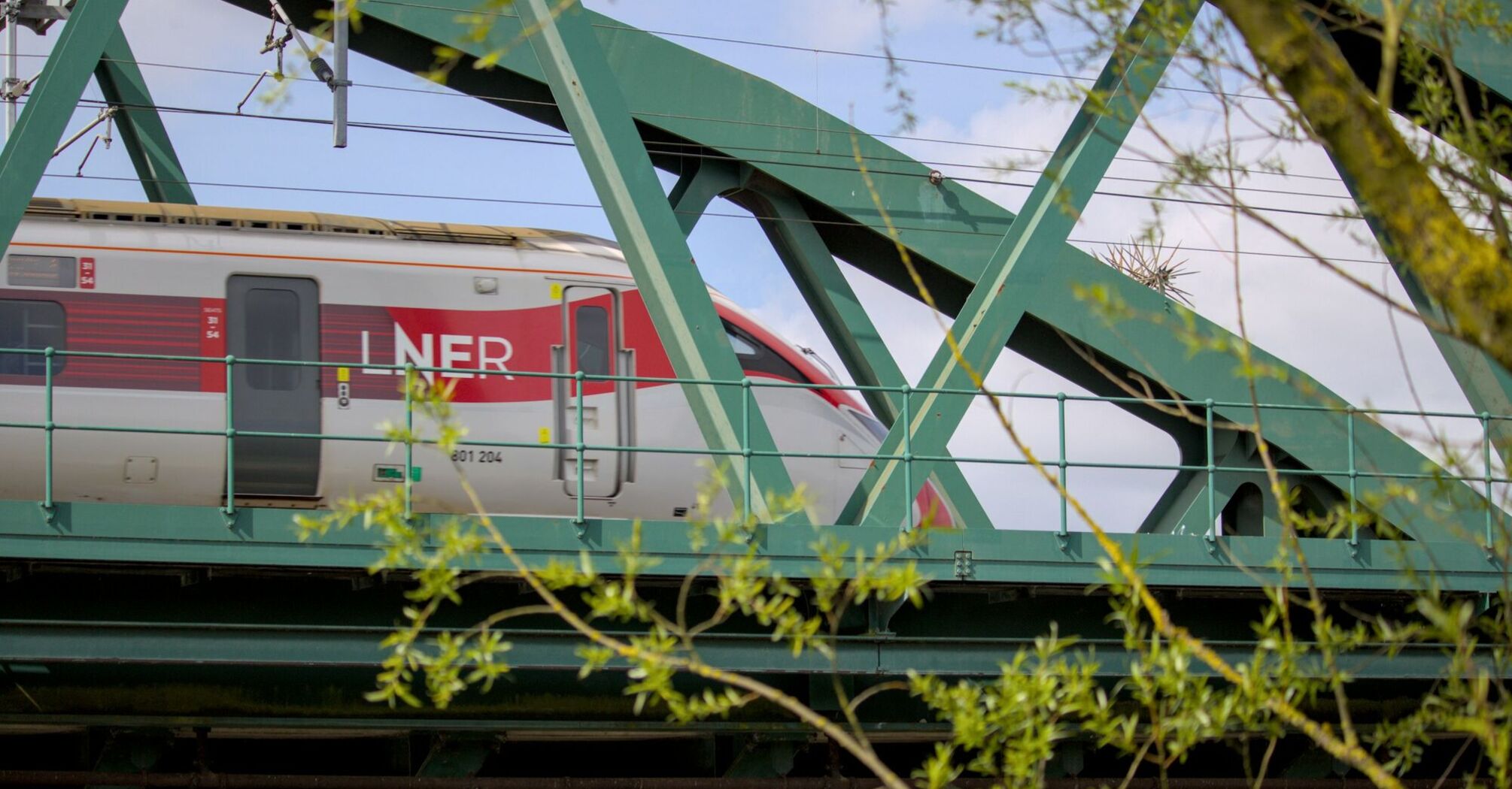 LNER train crossing a green steel bridge