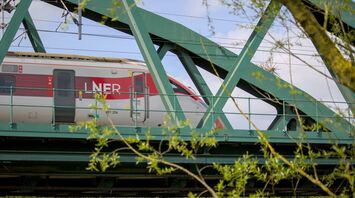 LNER train crossing a green steel bridge