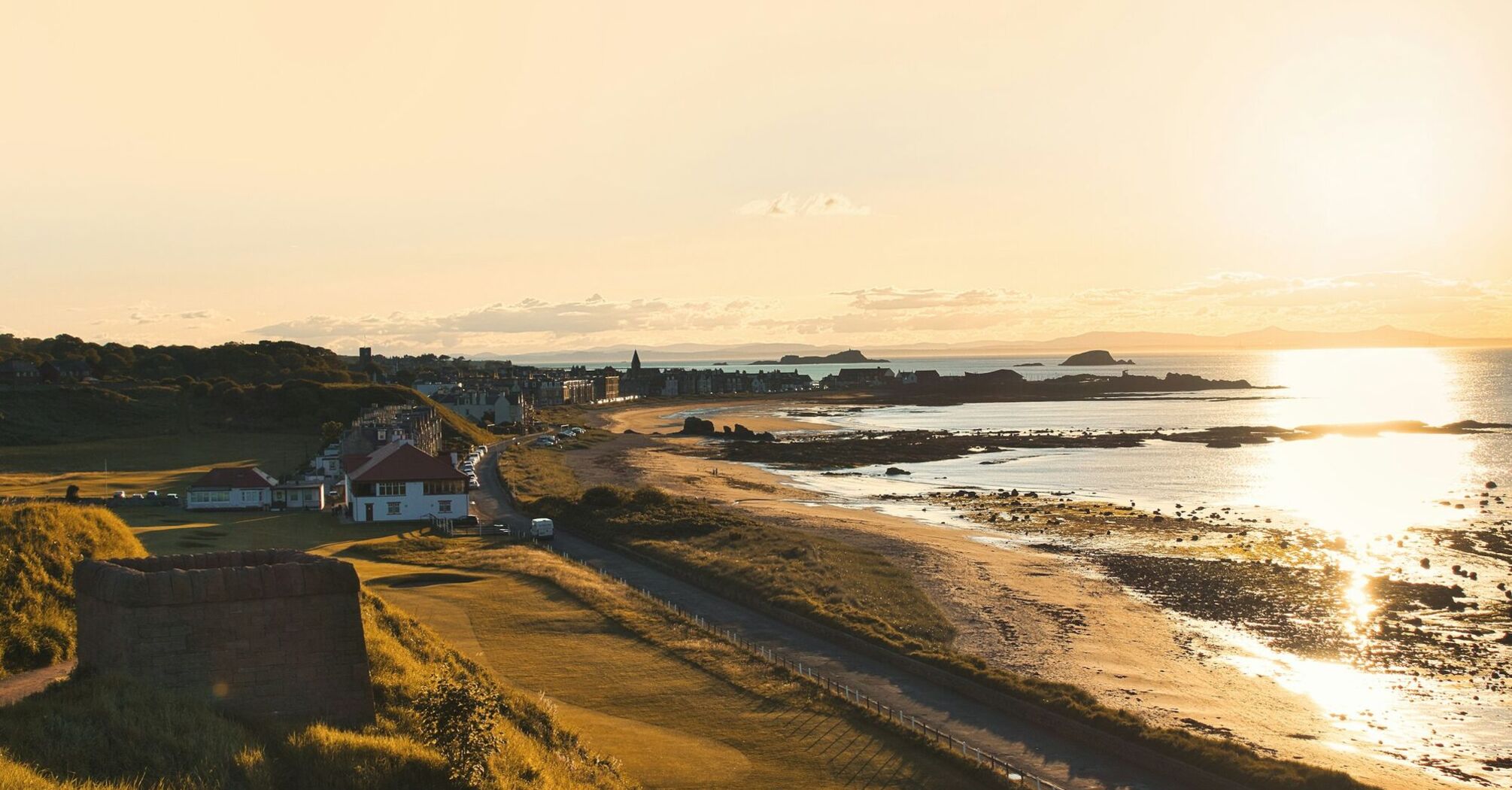 Sunset view of North Berwick coastline with buildings and beach in the distance