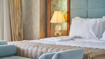 Hotel bed with a blue bench at the foot