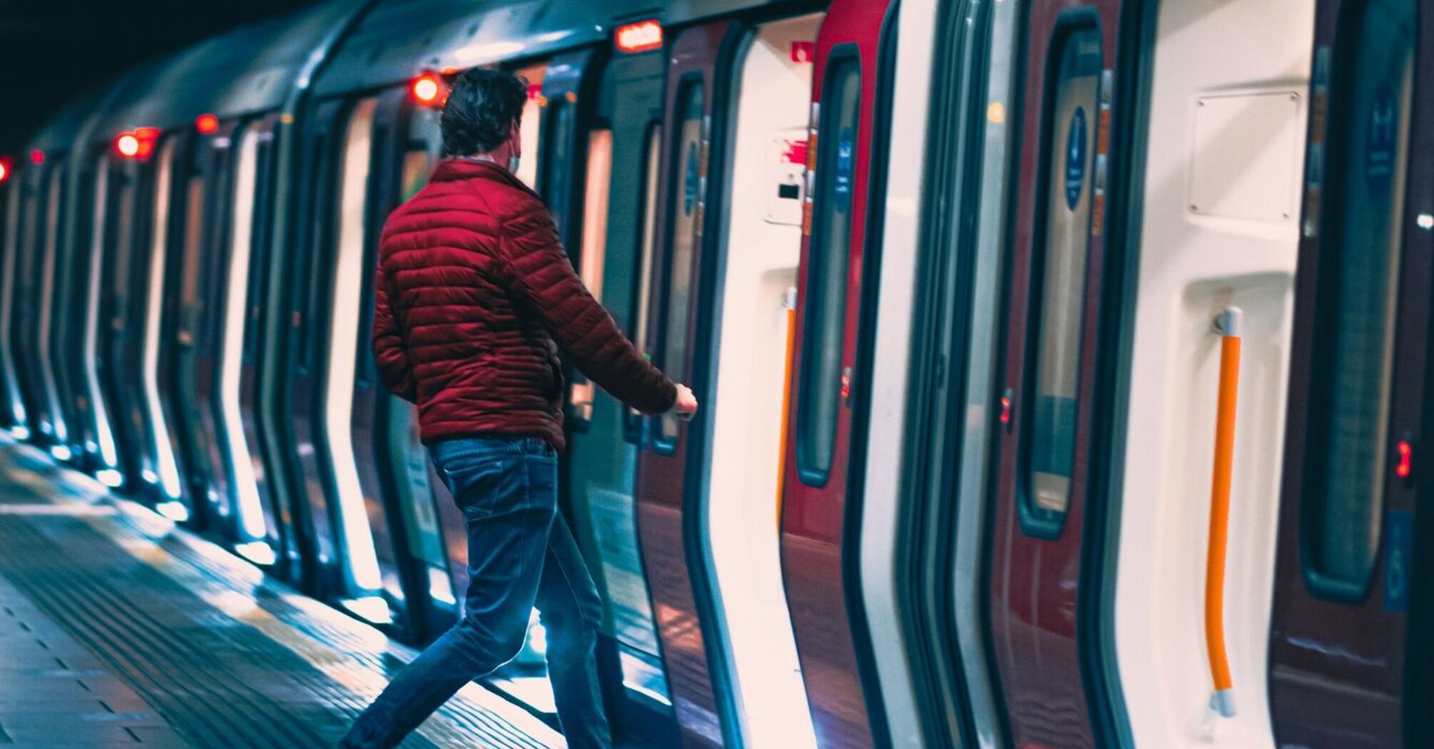A man boarding a train in a modern underground station