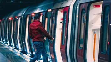 A man boarding a train in a modern underground station