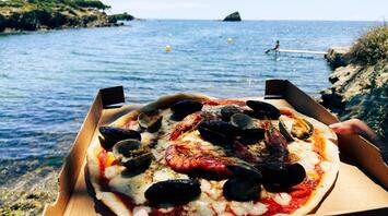 Pizza with seafood on the beach of Costa Brava