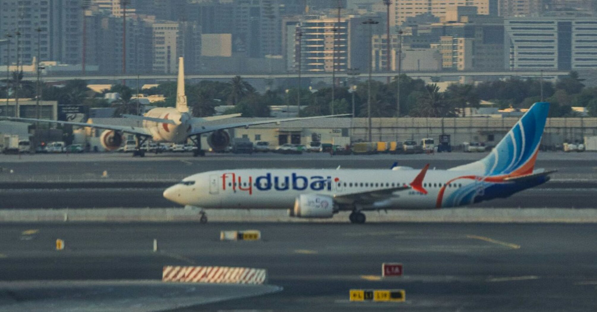 flydubai airplane at Dubai International Airport with city skyline in the background