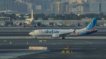 flydubai airplane at Dubai International Airport with city skyline in the background