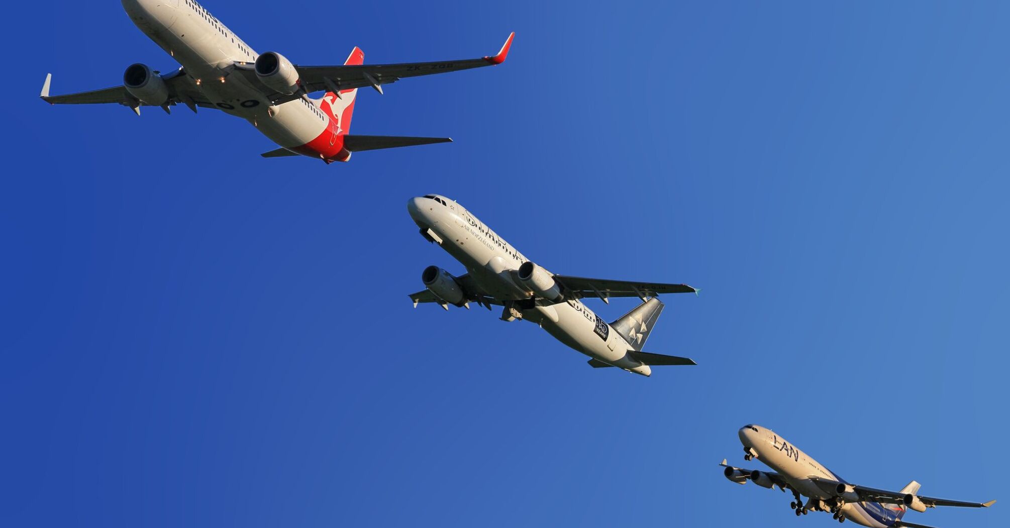 Three airplanes from different airlines in the sky