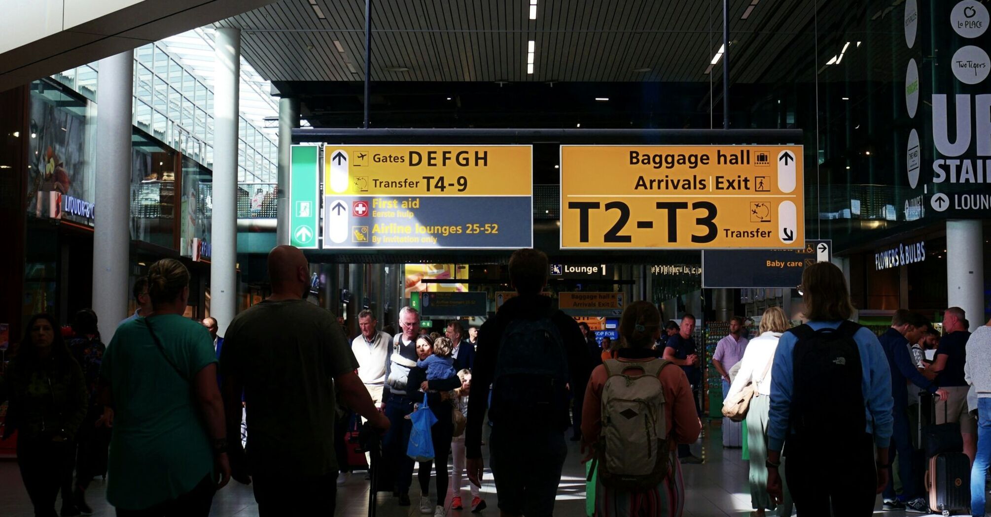 Crowded airport terminal with passengers and direction signs