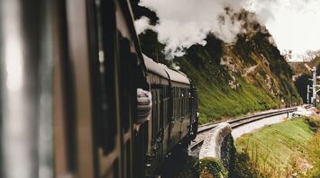 A vintage steam train traveling through scenic countryside