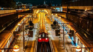 A tube train illuminated at night in a modern Uxbridge station