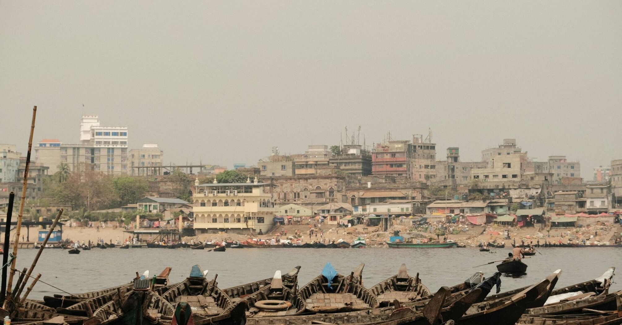 Boats docked near a crowded urban area in Bangladesh
