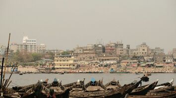 Boats docked near a crowded urban area in Bangladesh